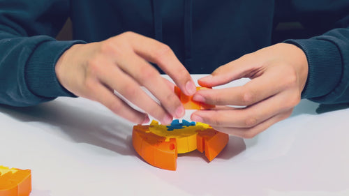Hands assembling the Orb-ix Solstice magnetic 3D puzzle