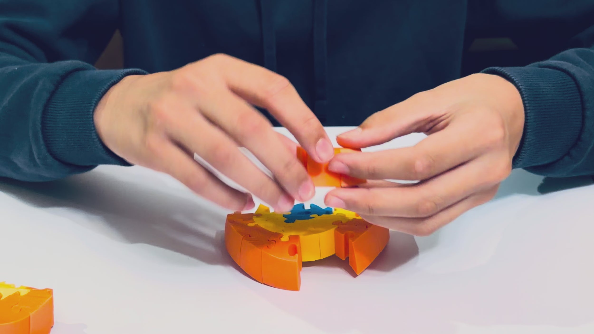 Hands assembling the Orb-ix Solstice magnetic 3D puzzle